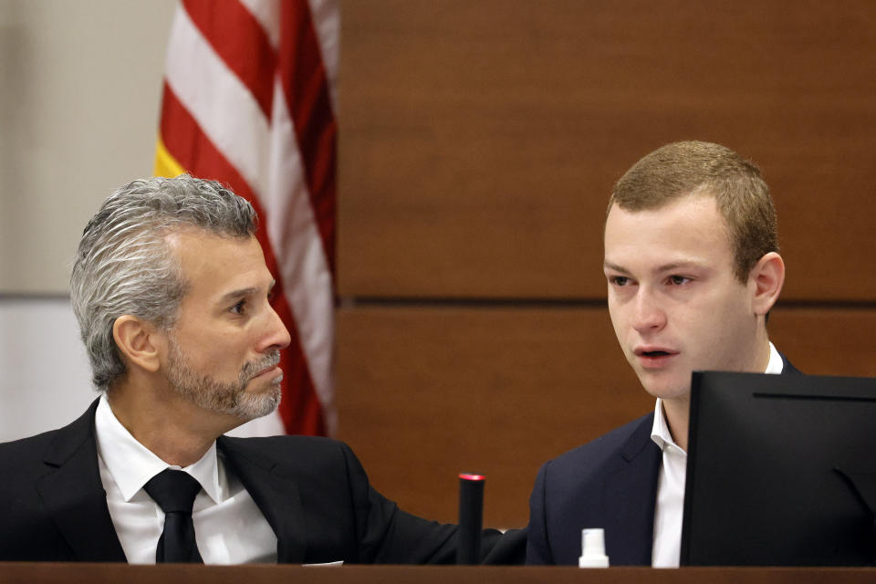 Max Schachter reaches out to his son, Ryan, while he reads a poem written by his brother, Alex, as he gives his victim impact statement during the penalty phase of the trial of Marjory Stoneman Douglas High School shooter Nikolas Cruz at the Broward County Courthouse in Fort Lauderdale, Fla., Wednesday, Aug. 3, 2022. Alex Schachter was killed in the 2018 shootings. Cruz previously plead guilty to all 17 counts of premeditated murder and 17 counts of attempted murder in the 2018 shootings. (Amy Beth Bennett/South Florida Sun Sentinel via AP, Pool)