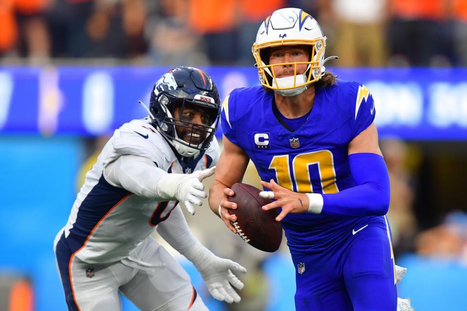 Dec 10, 2023; Inglewood, California, USA; Los Angeles Chargers quarterback <a class="link " href="https://sports.yahoo.com/nfl/players/32676" data-i13n="sec:content-canvas;subsec:anchor_text;elm:context_link" data-ylk="slk:Justin Herbert;sec:content-canvas;subsec:anchor_text;elm:context_link;itc:0">Justin Herbert</a> (10) moves out to pass against the defense of <a class="link " href="https://sports.yahoo.com/nfl/teams/denver/" data-i13n="sec:content-canvas;subsec:anchor_text;elm:context_link" data-ylk="slk:Denver Broncos;sec:content-canvas;subsec:anchor_text;elm:context_link;itc:0">Denver Broncos</a> linebacker <a class="link " href="https://sports.yahoo.com/nfl/players/33627" data-i13n="sec:content-canvas;subsec:anchor_text;elm:context_link" data-ylk="slk:Jonathon Cooper;sec:content-canvas;subsec:anchor_text;elm:context_link;itc:0">Jonathon Cooper</a> (0) during the first half at SoFi Stadium. Mandatory Credit: Gary A. Vasquez-USA TODAY Sports