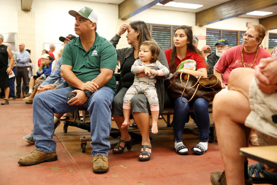 Puna District resident Ray Kaaihue (L), 47, listens with his wife Jennifer, 46, their daughter Kieryn, 22, and Kieryn's daughter, Karsyn, 1, during a community meeting on the ongoing eruptions&nbsp;on May 7, 2018.&nbsp;