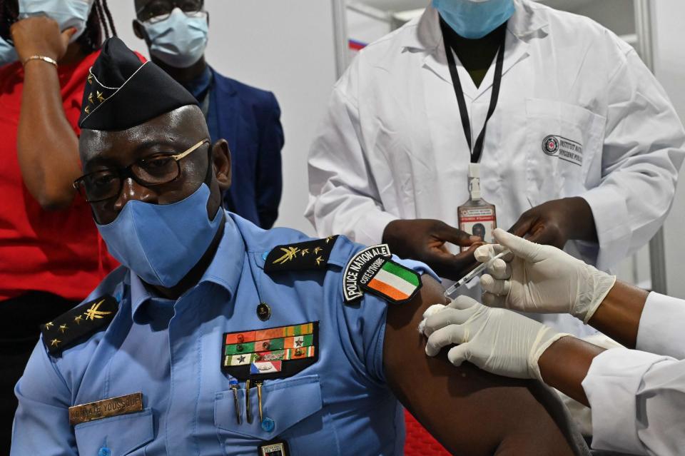 <p>An Ivory Coast police officer receives an AstraZeneca Covid-19 vaccine at the palais des sports in Abidjan </p> (AFP via Getty images)