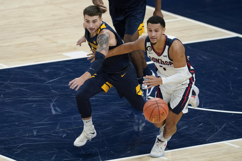 West Virginia's Jordan McCabe (5) and Gonzaga's Jalen Suggs (1) eye a loose during the first half of an NCAA college basketball game Wednesday, Dec. 2, 2020, in Indianapolis. (AP Photo/Darron Cummings)