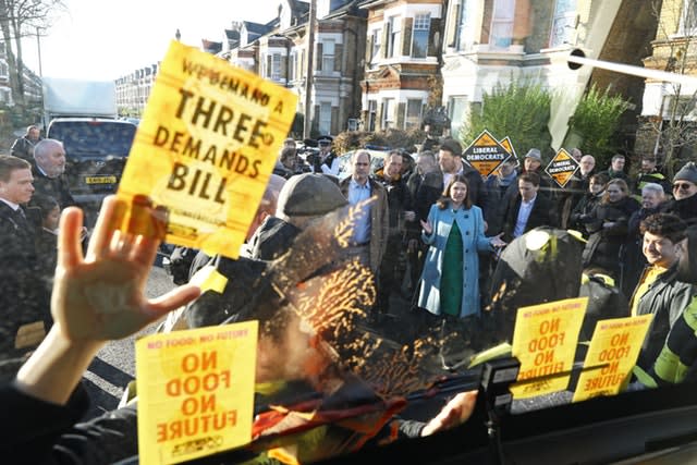 Jo Swinson speaks to Extinction Rebellion protesters dressed as bees after they glued themselves to the Lib Dems' battle bus during a visit to Knights Youth Centre in London 