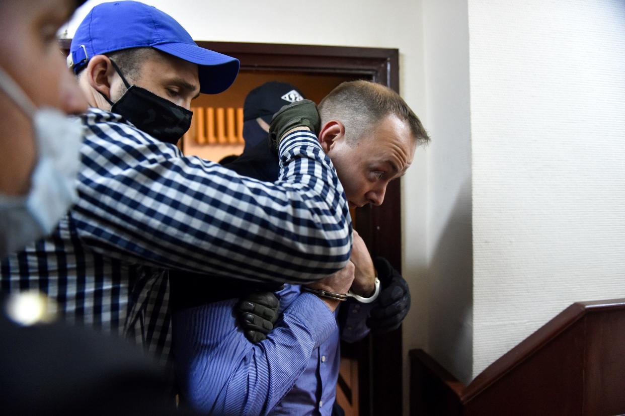 Ivan Safronov, a former journalist and aide to the head of Russia's space agency Roscosmos, is escorted inside a court building after being detained on charges of treason for divulging state military secrets, Moscow, July 7, 2020. / Credit: VASILY MAXIMOV/AFP/Getty