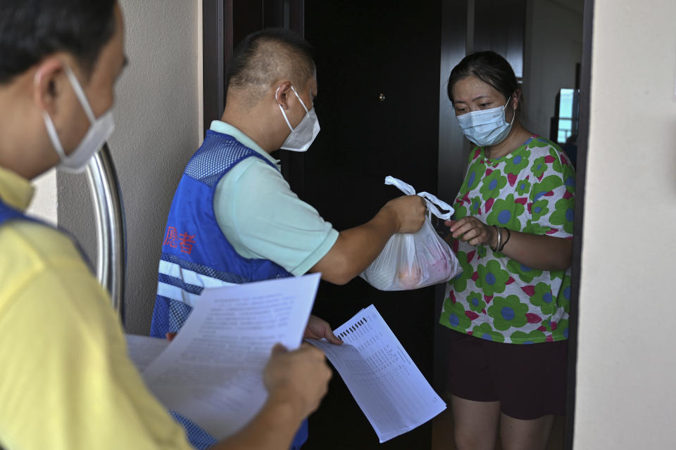 In this photo released by Xinhua News Agency, volunteers deliver fruits to a trapped tourist at a hotel in Sanya in south China's Hainan Province on Sunday, Aug. 7, 2022. The capital of China's Hainan province has locked down its residents for 13 hours as a COVID-19 outbreak grows on the tropical island during the summer school holidays. (Guo Cheng/Xinhua via AP)