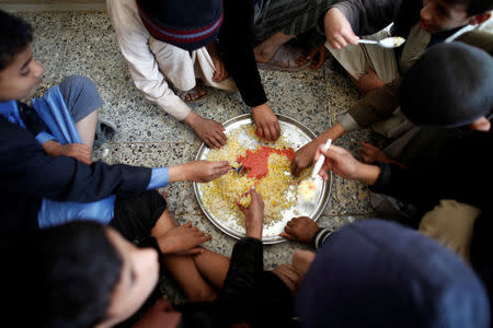 Boys eat rice for lunch at The al-Shawkani Foundation for Orphans Care in Sanaa, Yemen, December 25, 2016. REUTERS/Khaled Abdullah