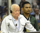 In this photo released by the Extraordinary Chambers in the Courts of Cambodia, Khieu Samphan, foreground, former Khmer Rouge head of state, stands at thea dock in a court room during a hearing at the U.N.-backed war crimes tribunal in Phnom Penh, Cambodia, Friday, Nov. 16, 2018. A U.N.-backed tribunal in Cambodia on Friday convicted the two most senior surviving leaders of the country's former Khmer Rouge regime of genocide and other crimes against humanity, sentencing them to life in prison. (Nhet Sok Heng/Extraordinary Chambers in the Courts of Cambodia via AP)