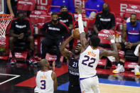 Philadelphia 76ers' Joel Embiid (21) goes up for a shot between Phoenix Suns' Deandre Ayton (22) and Chris Paul (3) during the second half of an NBA basketball game, Wednesday, April 21, 2021, in Philadelphia. (AP Photo/Matt Slocum)