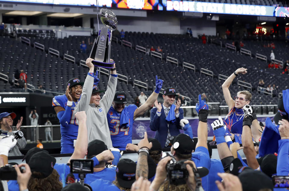 Boise State interim head coach Spencer Danielson holds up the trophy after the Mountain West championship NCAA college football game against UNLV, Saturday, Dec. 2, 2023, in Las Vegas. (Steve Marcus/Las Vegas Sun via AP)