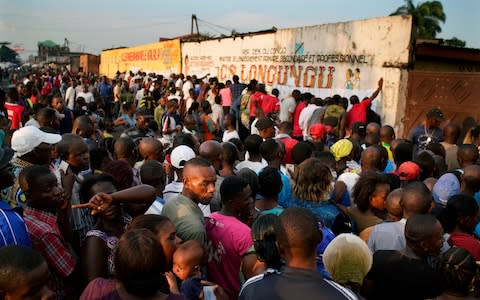 Voters at the Les Anges school polling station in Kinshasa burned voting machines and ballots at midday after registration lists failed to arrive; voting finally started at nightfall - Credit: Jerome Delay/AP