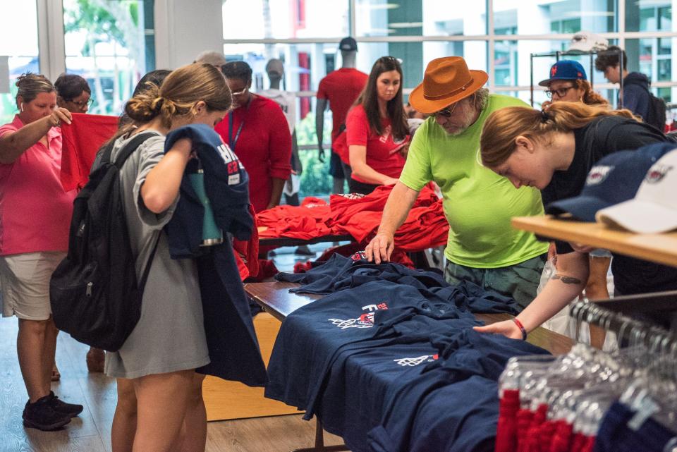 Customers at the FAU Campus Store browse t-shirts noting Florida Atlantic basketball's NCAA Tournament Final Four appearance on Wednesday, March 29, 2023, in Boca Raton, FL. FAU Campus store staff said the Tuesday afternoon shipment of merchandise celebrating the men's basketball team's appearance at the NCAA Tournament Final Four sold out the same day it arrived.