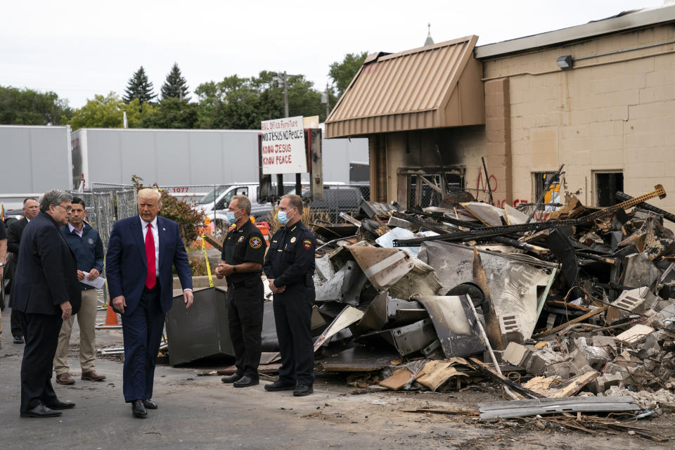 President Donald Trump walks Tuesday, Sept. 1, 2020, as he tours an area damaged during demonstrations after a police officer shot Jacob Blake in Kenosha, Wis. At left is Attorney General William Barr and acting Homeland Security Secretary Chad Wolf. (AP Photo/Evan Vucci)