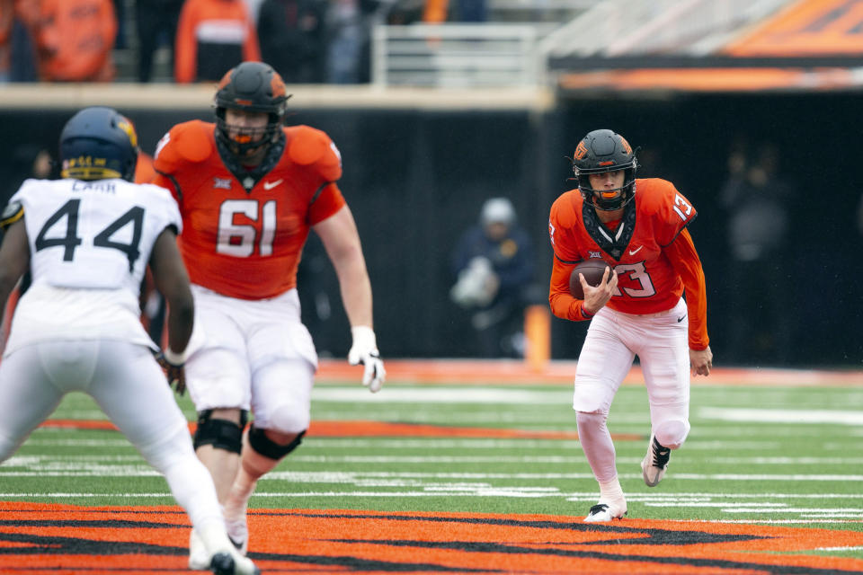 Oklahoma State quarterback Garret Rangel runs the ball during the first half of the NCAA college football game against West Virginia in Stillwater, Okla., Saturday Nov. 26, 2022. (AP Photo/Mitch Alcala)