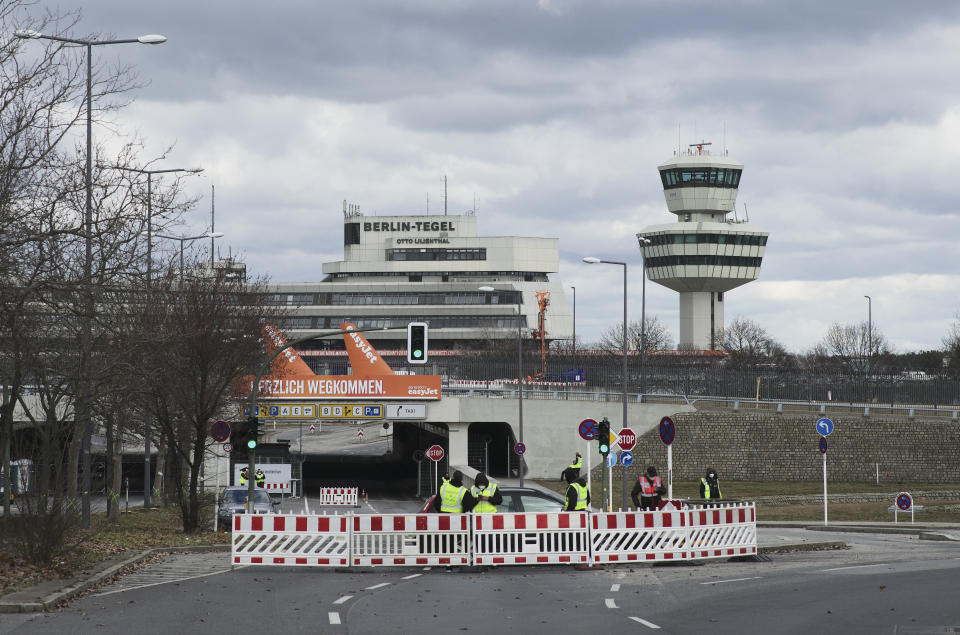 The entrance road of the former airport Tegel which is now used as a vaccination center for vaccination with AstraZeneca is blocked in Berlin, German, Tuesday, March 16, 2021. Germany and other EU countries have suspended use of the AstraZeneca vaccine. (AP Photo/Markus Schreiber)