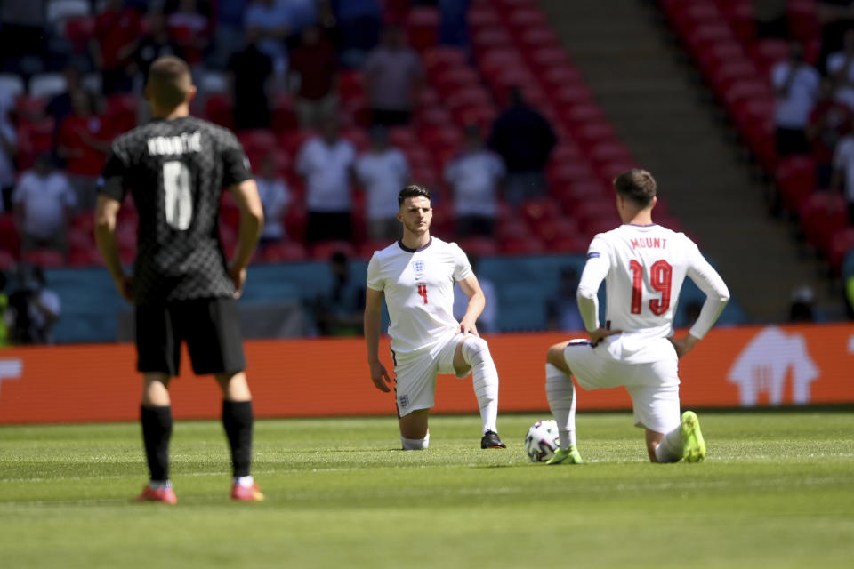 England's Mason Mount, right, and Declan Rice take the knee pair to the kick-off of the Euro 2020 soccer championship group D match between England and Croatia, at Wembley stadium, London, Sunday, June 13, 2021. (Laurence Griffiths, Pool via AP)