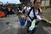 Women holding crying children by the hand or pressing their infants to their chests streamed past the broken metal barriers and onto the bridge into Mexico