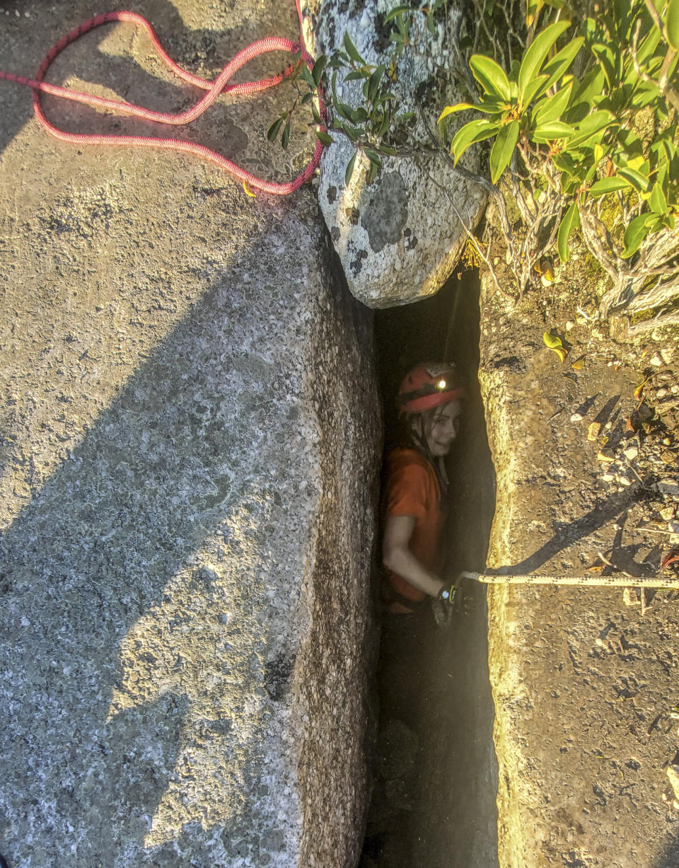 This photo provided by New York State Parks on Wednesday, Oct. 13, 2021, shows parks official Jessica Van Ord entering a fissure to rescue a 12-year-old dog named Liza, found trapped after five days deep inside the narrow, rocky crevice at Minnewaska State Park Preserve in Kerhonkson, N.Y. A dog trapped for five days deep inside a narrow, rocky crevice at a state park north of New York City was rescued unharmed — though it was hungry and thirsty, parks officials said Wednesday.(New York State Parks via AP)