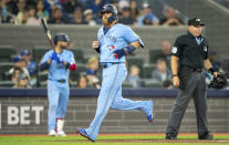 Toronto Blue Jays' Justin Turner, center, crosses the plate to score against the Los Angeles Dodgers during second-inning baseball game action in Toronto, Sunday, April 28, 2024. (Frank Gunn/The Canadian Press via AP)