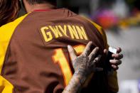 Chanda Anderson, 39, embraces her boyfriend Sean Robison, 36, at a makeshift memorial to former San Diego Padres outfielder Tony Gwynn at Petco Park in San Diego, California June 16, 2014. Gwynn, one of the greatest hitters of his generation, died on Monday at age 54 after a battle with cancer, the National Baseball Hall of Fame and Museum said. REUTERS/Sam Hodgson (UNITED STATES - Tags: SPORT BASEBALL OBITUARY)