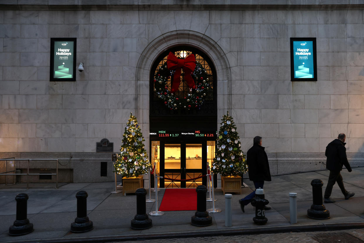 People walk by holiday decorations at the New York Stock Exchange (NYSE) in New York City, U.S., December 14, 2022. REUTERS/Andrew Kelly