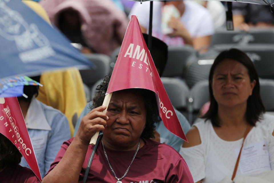 A supporter of Mexico's President Andres Manuel Lopez Obrador waits for him at the Zocalo in Mexico City, Mexico, Monday, July 1, 2019. Lopez Obrador will deliver a speech to mark his first year in office. (AP Photo/Fernando Llano)