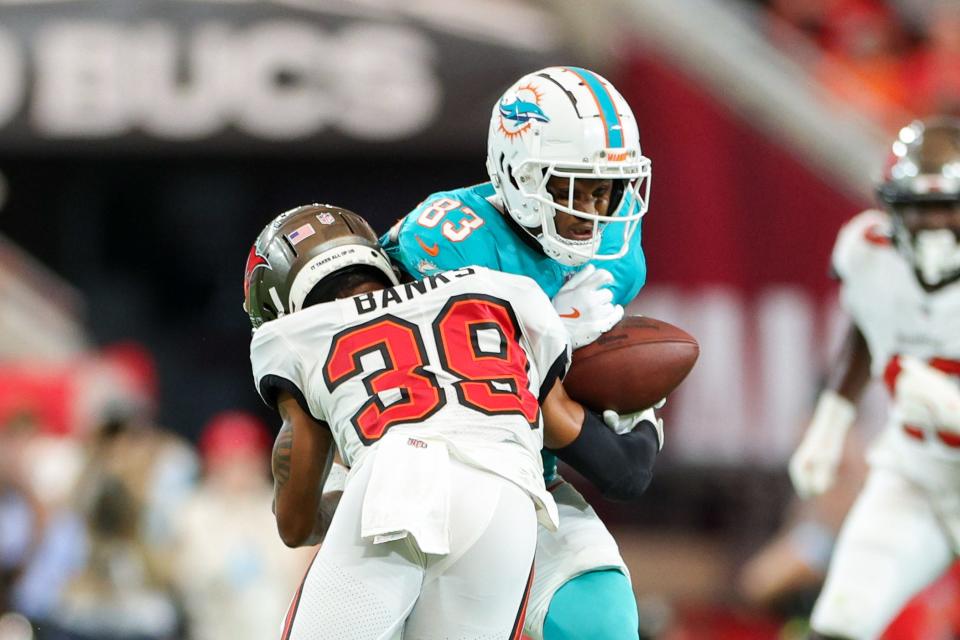 Aug 23, 2024; Tampa, Florida, USA; Tampa Bay Buccaneers safety Marcus Banks (39) hits Miami Dolphins wide receiver Malik Washington (83) in the first quarter during preseason at Raymond James Stadium. Mandatory Credit: Nathan Ray Seebeck-USA TODAY Sports