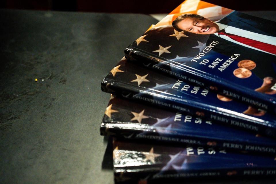 Copies of presidential candidate Perry Johnson's book "Two Cents to Save America" sit on a table during a campaign event at Peace Tree Brewing on Wednesday, July 12, 2023 in Des Moines. 