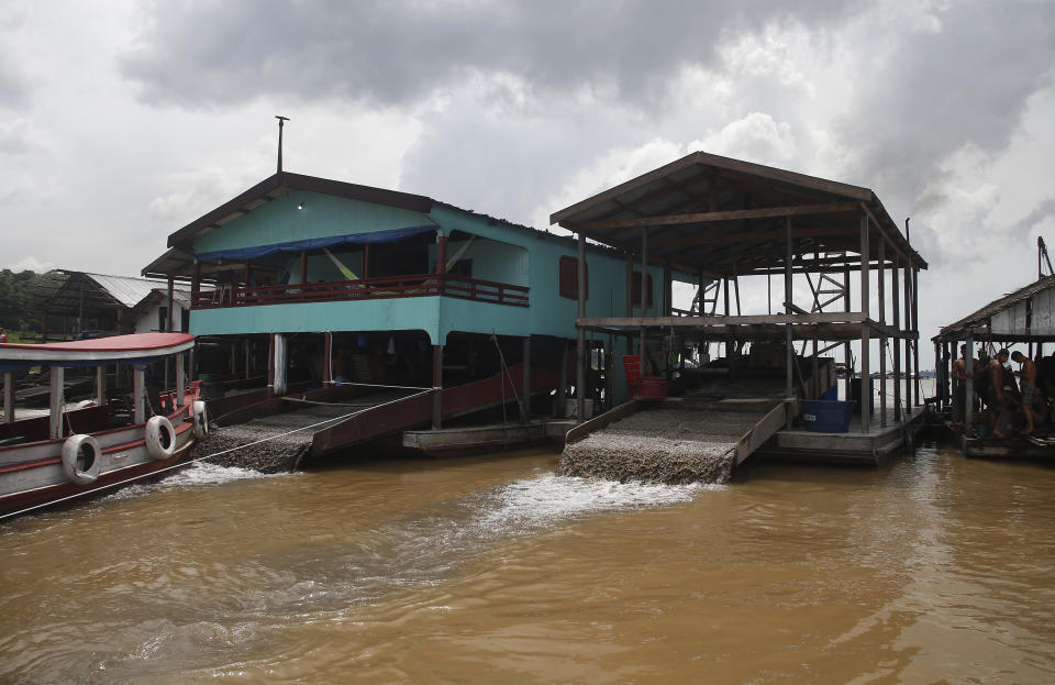 Dredging barges operated by illegal miners converge on the Madeira river, a tributary of the Amazon river, searching for gold, in Autazes, Amazonas state, Brazil, Thursday, Nov.25, 2021. Hundreds of mining barges have arrived during the past two weeks after rumors of gold spread, with environmentalists sounding the alarm about the unprecedented convergence of boats in the sensitive ecosystem. (AP Photo/Edmar Barros)