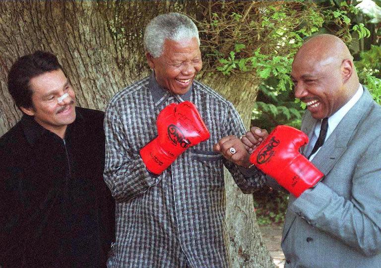 Nelson Mandela pretends to fight former US world middleweight champion Marvin Hagler (right) at his residence in Cape Town on November 12, 1997