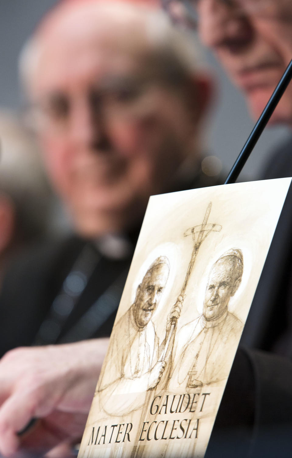 Director of the Holy See Press Room Father Federico Lombardi, right, flanked by Cardinal Agostino Vallini, speaks during a press conference at the Vatican, Monday, March 31, 2014, on the canonisation of two late popes John XXIII, at left in the picture, and John Paul II, at right in the picture, who will be made saints on April 27, 2014. The simple, low-frills style of Pope Francis is having an effect on the upcoming canonizations of Popes John Paul II and John XXIII. Organizers of the event said Monday the April 27 saint-making ceremony will be a much more sober affair compared to the three-day extravaganza that accompanied John Paul's 2011 beatification. That 2011 event included a prayer vigil on Rome's Circus Maximus field for tens of thousands of people and ended up costing several times the original estimate of 1.2 million euros. (AP Photo/Domenico Stinellis)