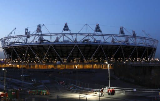 A workman passes by the Olympic Stadium in east London. The theme of the opening ceremony of the London Olympics will be "Isles of Wonder", film director Danny Boyle, who is the ceremony's artistic director, has revealed