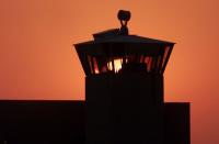 FILE PHOTO: The sun sets behind one of the guard towers at the Federal Penitentiary in Terre Haute