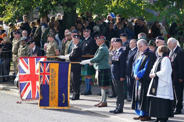 Dignitaries in Ballater watch the hearse 