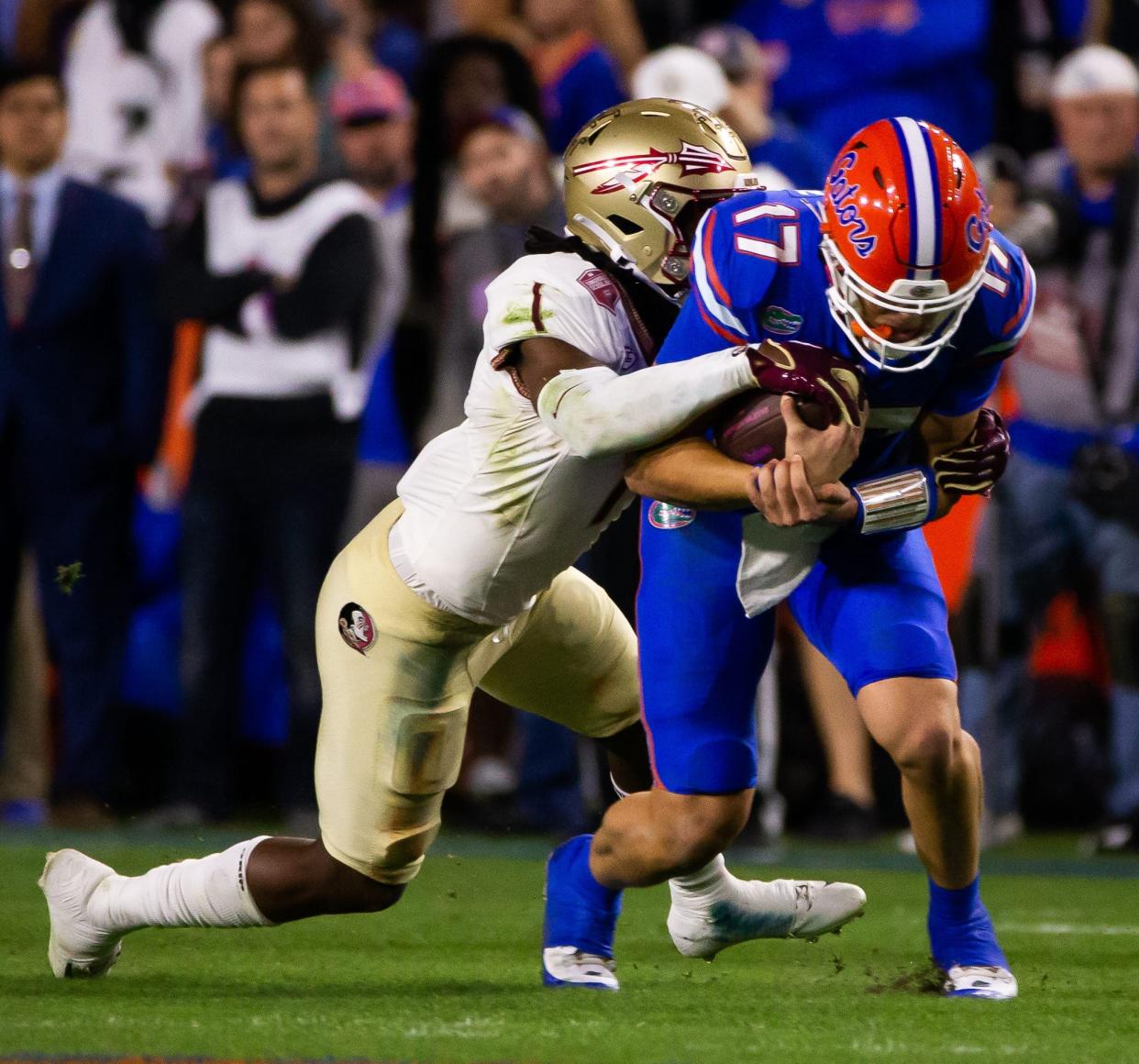 Florida Gators quarterback Max Brown (17) is tackled by Florida State Seminoles defensive back Akeem Dent (1) at Steve Spurrier Field at Ben Hill Griffin Stadium in Gainesville, FL on Saturday, November 25, 2023 during the first half. [Doug Engle/Gainesville Sun]