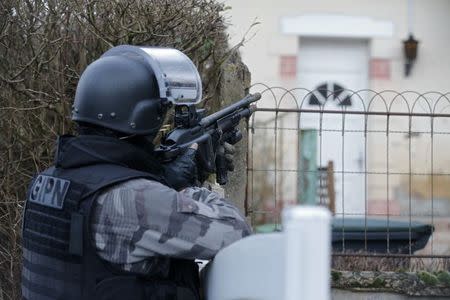 A member of the French GIPN intervention police forces secures a neighbourhood in Corcy, northeast of Paris, January 8, 2015. REUTERS/Christian Hartmann