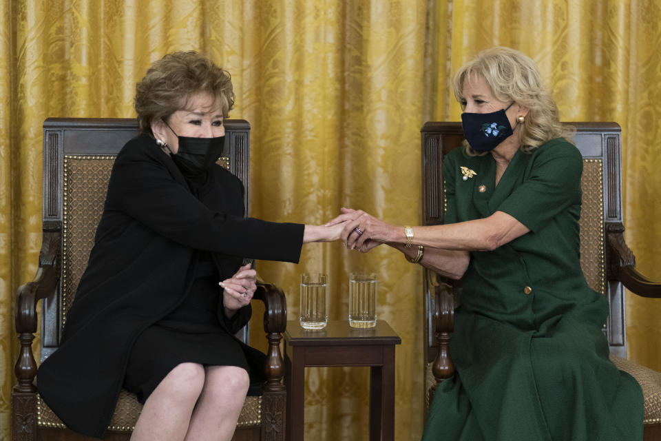 First lady Jill Biden, right, holds the hand of former Sen. Elizabeth Dole, R-N.C., as Dole is acknowledged during a ceremony at the White House honoring children in military and veteran caregiving families, Wednesday, Nov. 10, 2021. (AP Photo/Manuel Balce Ceneta)