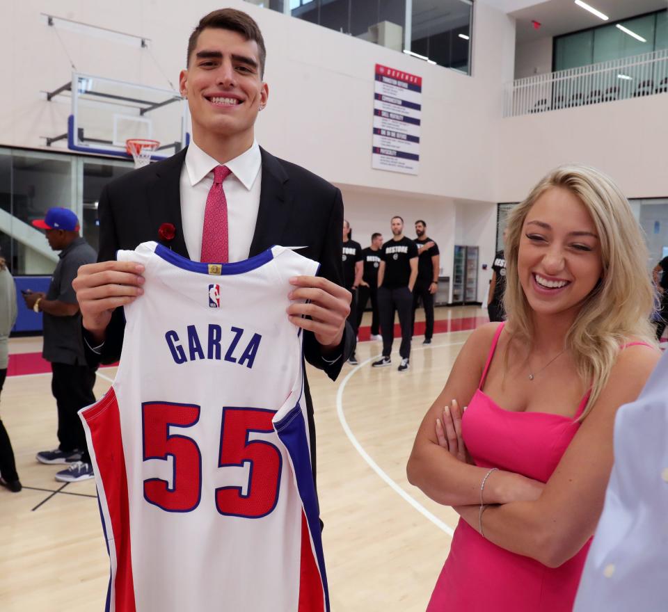 Pistons second-round draft pick Luka Garza holds upholds up his game jersey with his girlfriend, Maggie Mynderse, after the news conference on Friday, July 30, 2021, at the team's practice facility in Detroit.