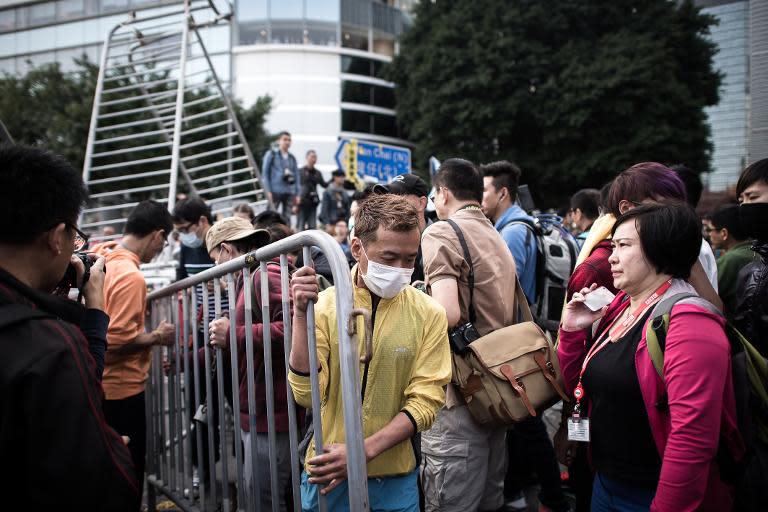 Pro-democracy protesters remove a barricade outside the Citic tower near a protest site in the Admiralty district of Hong Kong, on November 18, 2014