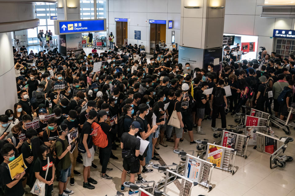 Protesters hold placards as they block the departure gate of the Hong Kong International Airport Terminal 2 during a demonstration on August 13, 2019 in Hong Kong, China. (Photo: Anthony Kwan/NurPhoto via Getty Images)