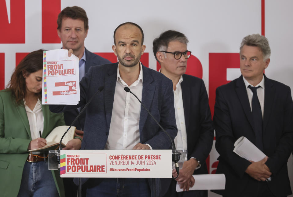 Far-left Manuel Bompard, show the contrat for the upcoming election during a media conference as Green Party Marine Tondelier, Green Party Yannick Jadot, Socialist Party Secretary General Olivier Faure and Communist Party national secretary Fabien Roussel stand behind him in Paris, Friday, June 14, 2024. Leaders of France's left-wing parties, allied in a coalition known as the New Popular Front on Friday outlined their plan to fend off the far-right from claiming power at the upcoming snap national election. (AP Photo/Thomas Padilla)