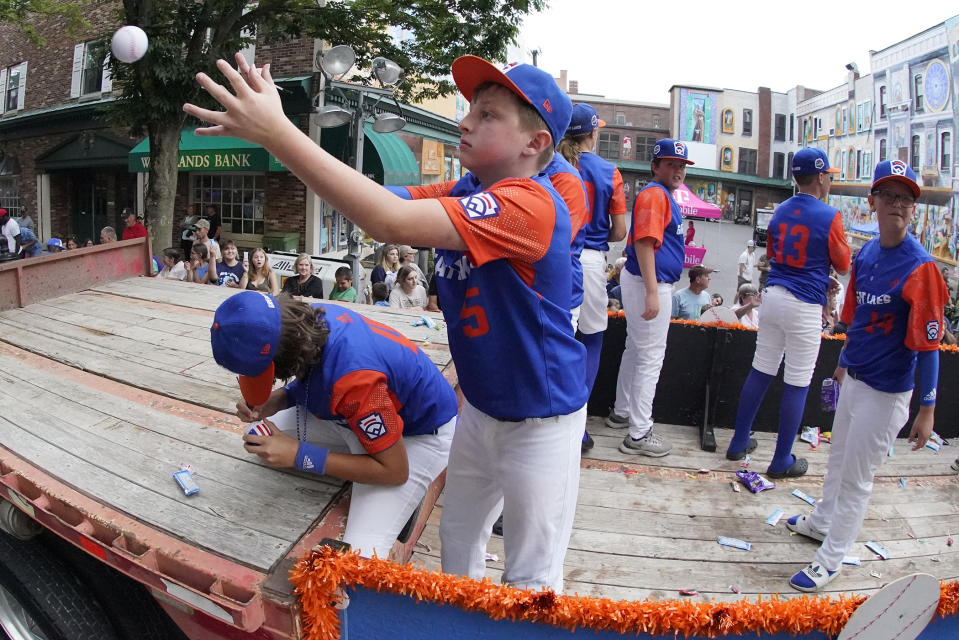 The Great Lakes Region champion Little League team from Hagerstown, Indiana, rides in the Little League Grand Slam Parade in downtown Williamsport, Pa., on Monday, Aug. 15, 2022. The Little League World Series baseball tournament, featuring 20 teams from around the world, starts Wednesday in South Williamsport, Pa. (AP Photo/Gene J. Puskar)