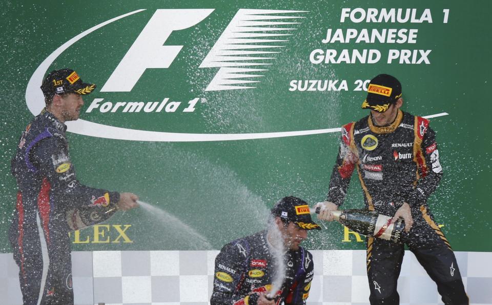 Red Bull Formula One driver Sebastian Vettel (L) of Germany celebrates on the podiun with second-placed Red Bull Formula One driver Mark Webber of Australia and third-placed Lotus Formula One driver Romain Grosjean (R) of France after winning the Japanese F1 Grand Prix at the Suzuka circuit October 13, 2013. REUTERS/Toru Hanai (JAPAN - Tags: SPORT MOTORSPORT F1)