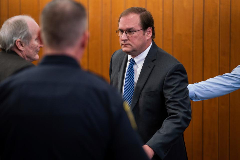 David Sutherland, an attorney who has been charged with embezzling hundreds of thousands of dollars from recently deceased Carhartt heiress Gretchen Valade's trust, right, stands after his arraignment hearing at Grosse Pointe Farms Municipal Court on Jan. 11, 2023.