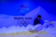 A staff member works near the emblem for Beijing 2022 Winter Olympics displayed at the Shanghai Sports Museum in Shanghai