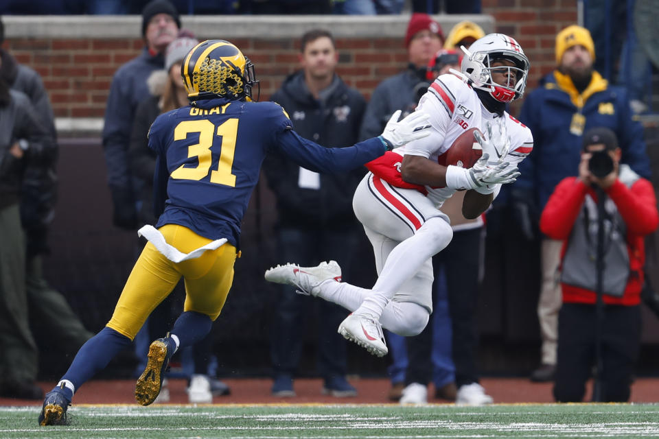 Ohio State wide receiver Garrett Wilson (5) catches a 47-yard pass as Michigan defensive back Vincent Gray (31) defends in the first half of an NCAA college football game in Ann Arbor, Mich., Saturday, Nov. 30, 2019. (AP Photo/Paul Sancya)