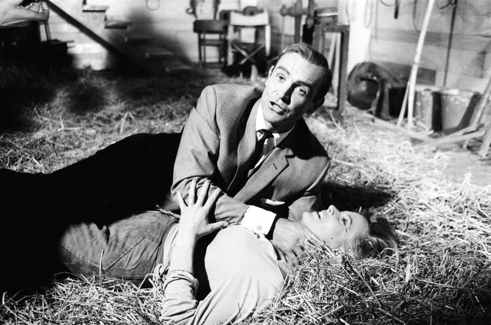 Honor Blackman as Pussy Galore and Sean Connery as James Bond seen here filming a fight scene which develops into a love scene in Goldfingers barn on the Pinewood studios back lot. 2nd June 1964