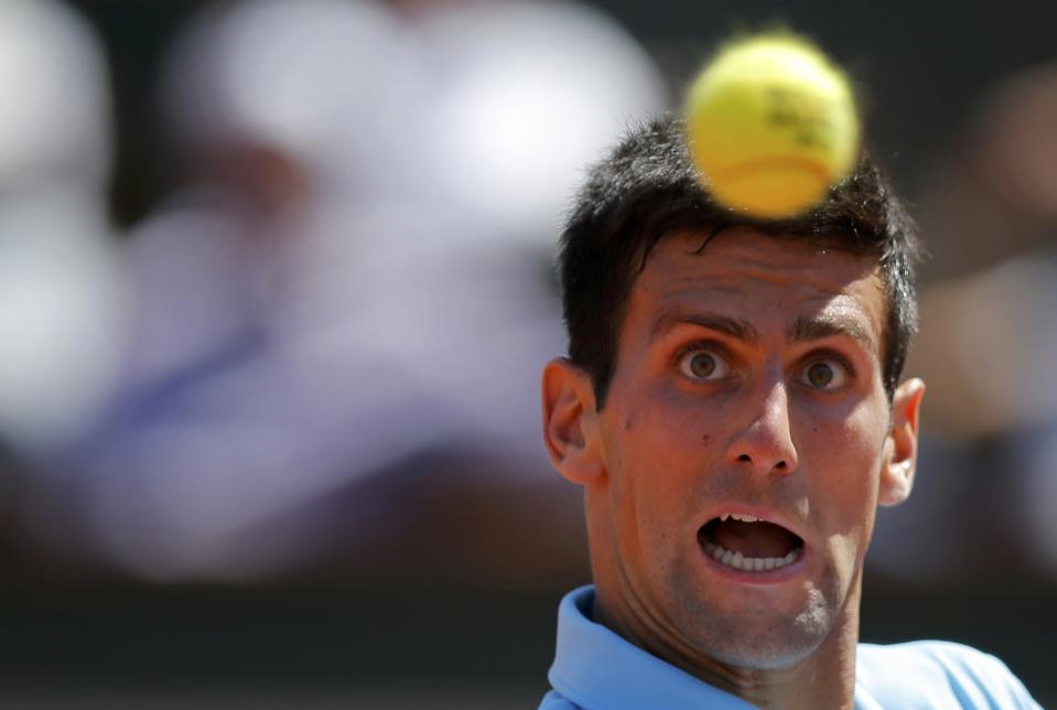 Novak Djokovic of Serbia eyes the ball during his men's semi-final match against Ernests Gulbis of Latvia at the French Open tennis tournament at the Roland Garros stadium in Paris