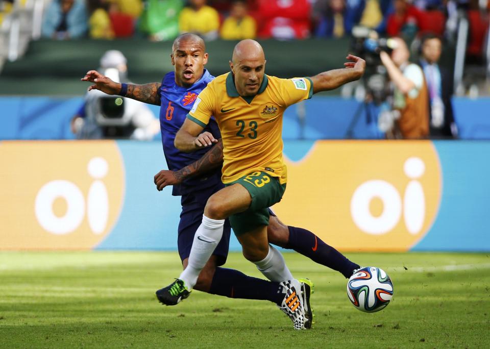 Nigel de Jong of the Netherlands (L) fights for the ball with Australia's Mark Bresciano during their 2014 World Cup Group B soccer match at the Beira Rio stadium in Porto Alegre June 18, 2014. REUTERS/Stefano Rellandini (BRAZIL - Tags: SOCCER SPORT WORLD CUP)