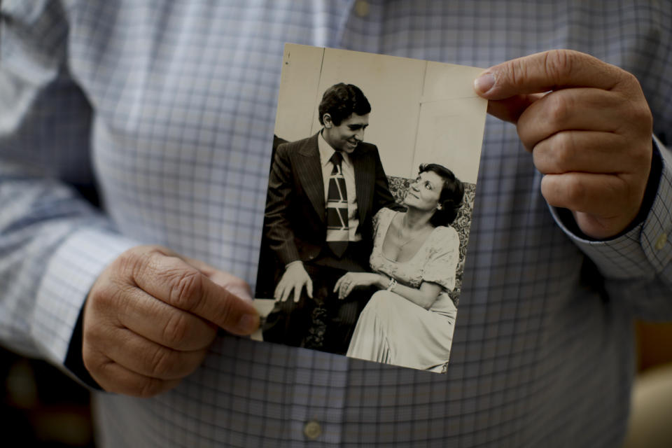 Doctor Augusto Briceno shows a picture of himself with his mother Ines Nivia Frascino, who passed away on July 26, a victim of COVID-19, at his home on the outskirts of Buenos Aires, Argentina, Saturday, Aug. 15, 2020. Briceno is happy he could say goodby to his mother in person before she died. “I would have not wanted to see her fight alone.” Briceño said. (AP Photo/Natacha Pisarenko)