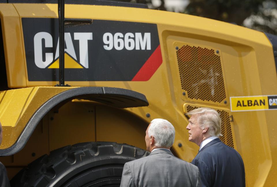 President Donald Trump and Vice President Mike Pence stop to looks at a Caterpillar truck, manufactured in Illinois, on the South Lawn of the White House in Washington, Monday, July 17, 2017, during a