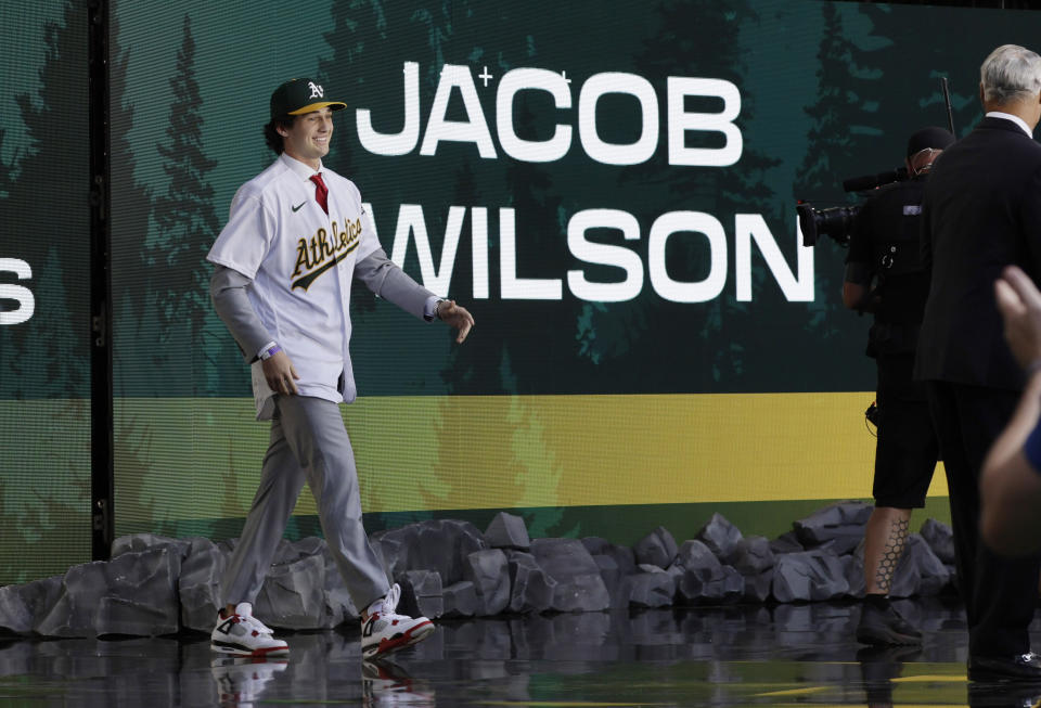 Jacob Wilson walks to the stage as the pick by the Oakland Athletics in baseball's amateur draft, Sunday, July 9, 2023, in Seattle. (AP Photo/John Froschauer)
